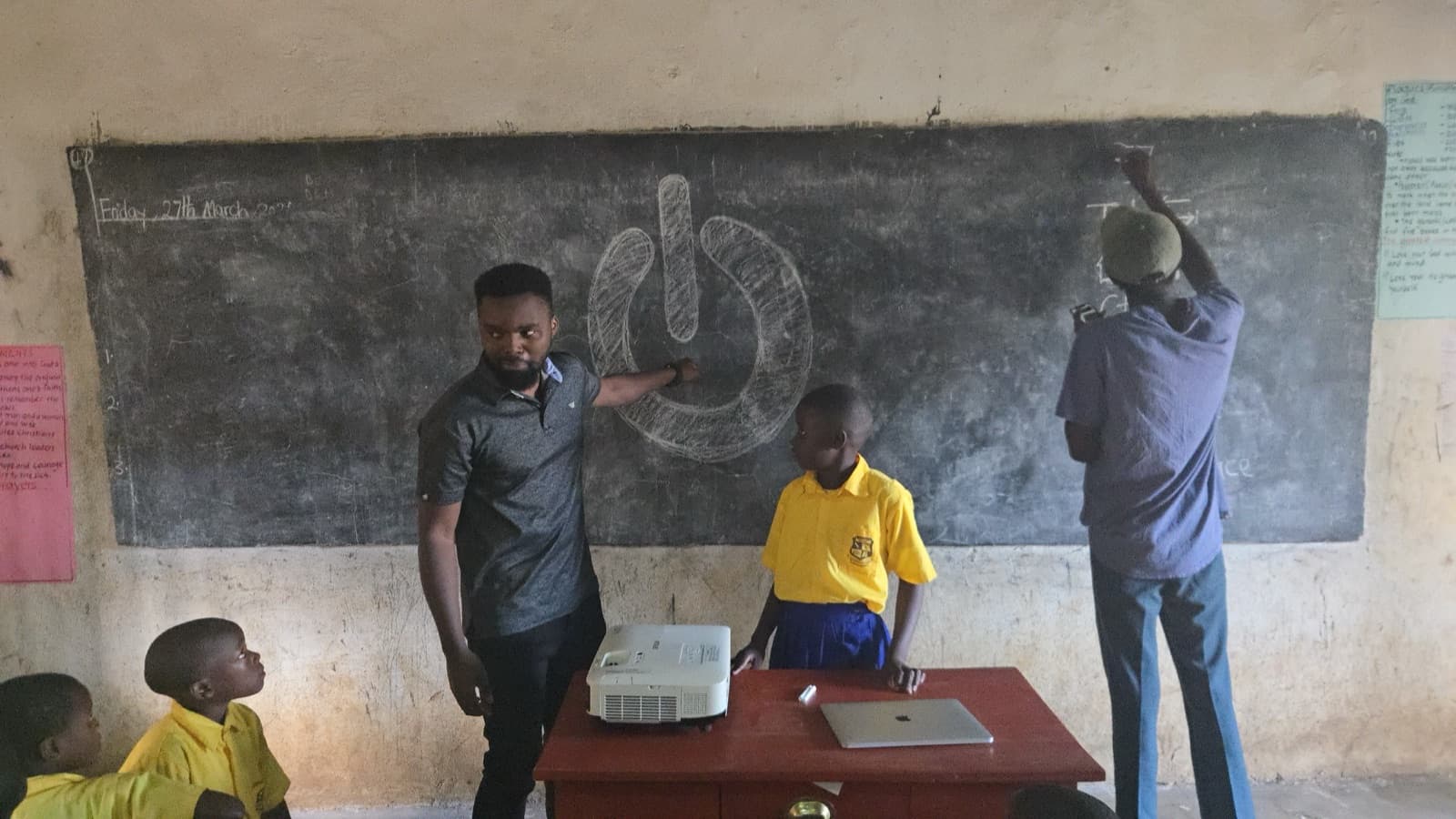 Facilitator drawing the power button on the chalkboard
